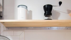 A kitchen with a coffee maker, a grinder, and a jar of coffee beans. - Renovated basement studio in historic Mapleton Hill. (Boulder)