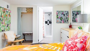 A modern bedroom with a bed, a desk, and a walk-in closet. - Renovated basement studio in historic Mapleton Hill. (Boulder)