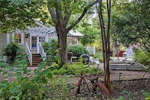 A house with a porch, a bicycle, and a car in the background. - Nut House Countryside Pecan Farm 14 ac San Marcos (Maxwell)