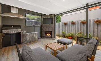 The outdoor area is a highlight for many guests, featuring a gas fireplace for cosy evenings