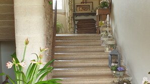 Una escalera con plantas en macetas y una silla de madera.