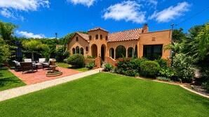 A house with a patio, outdoor furniture, and a well-maintained lawn. - Historic Spanish Home - Walk to the Beach, Restaurants and Shopping! (Encinitas)