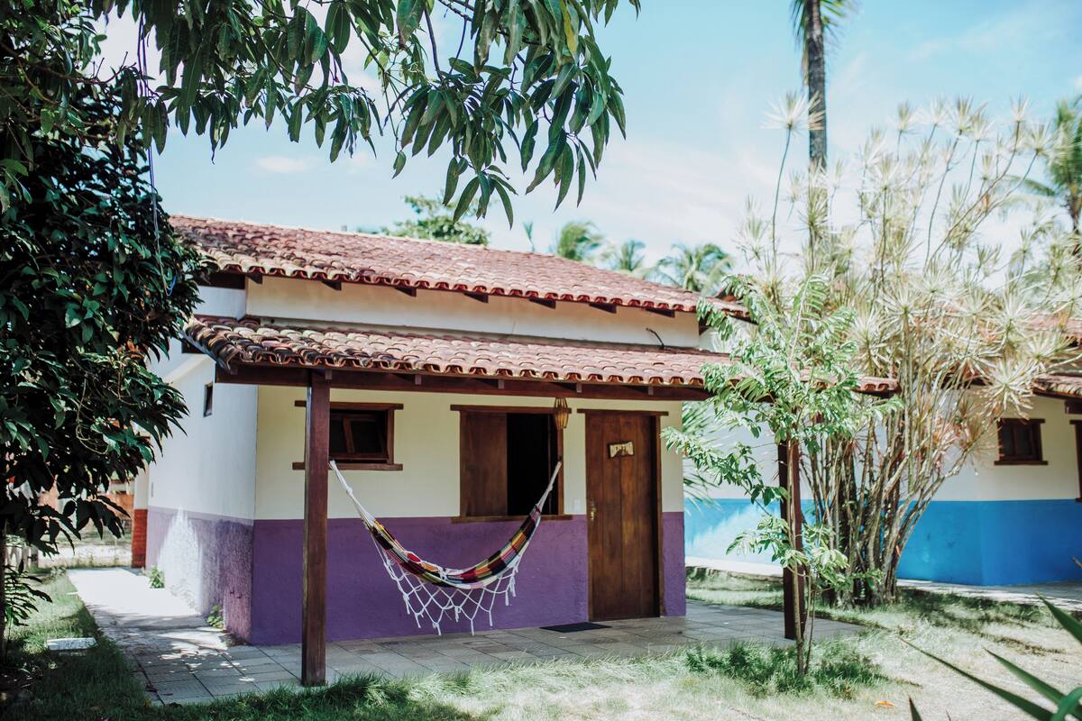 A small house with a tiled roof, a door, and a window.