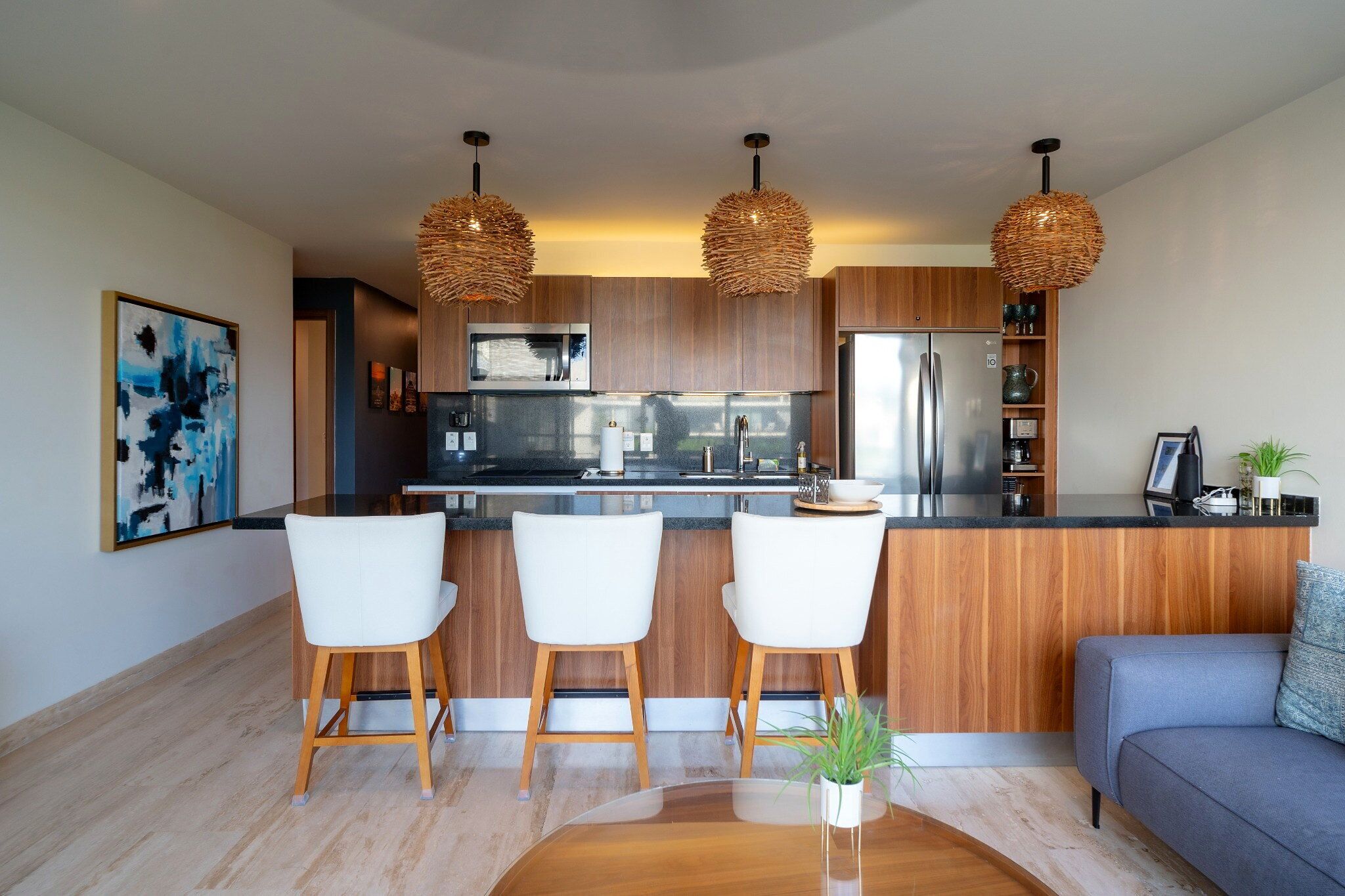 A modern kitchen with a central island, stainless steel appliances, and wooden cabinetry.