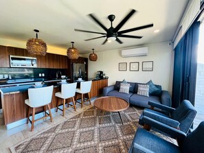 Een moderne keuken met een centraal eiland, een bar en een plafondventilator.