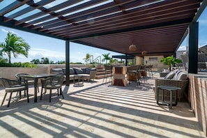 An outdoor patio with a pergola, seating, and a view of the surrounding landscape. - Luxury Playacar Penthouse with Private Rooftop Plunge Pool - Sleeps 9 (Playa del Carmen)