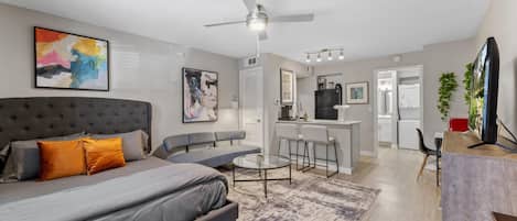 Un appartement moderne comprenant un grand lit, un canapé, un coin repas et une cuisine.