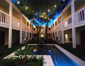 A pool area with a tree overhead and seating on both sides. - Chic 2BR Near Triangle With King Beds Fast Wifi (Austin)