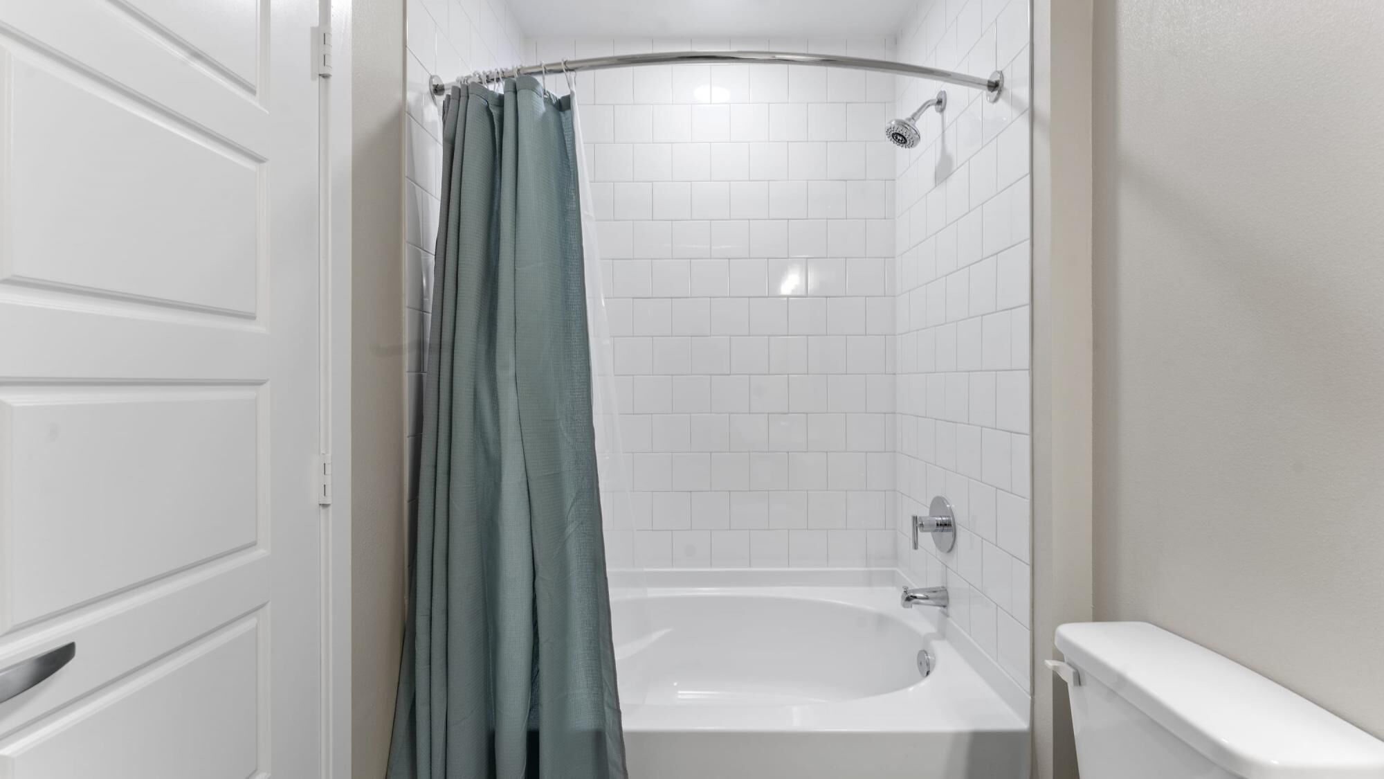 Un baño con una bañera blanca, ducha e inodoro.