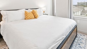 A bedroom with a bed, a ceiling fan, and a window with blinds. - Prime Soco Quaint 1BR King Suite w Pool Parking (Austin)