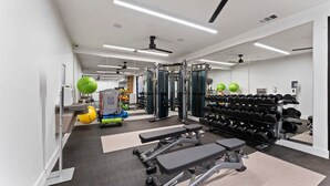 A modern gym with weightlifting equipment, treadmills, and exercise balls. - Prime Soco Quaint 1BR King Suite w Pool Parking (Austin)