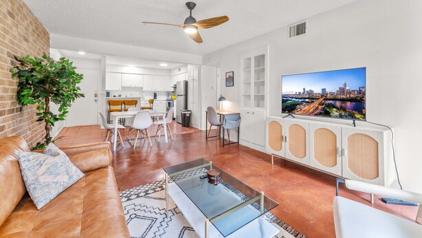 A modern living room with a sofa, coffee table, and TV. - Prime Soco Airy 1BR King Suite w Pool Parking (Austin)