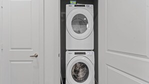 A laundry room with two stacked Whirlpool washing machines.