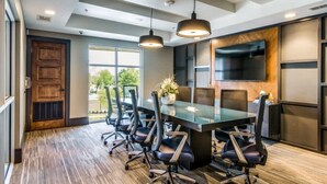 A modern meeting room with a large table, six chairs, pendant lighting, and a built-in TV. - Cozy 1BR King Suite Close to Downtown w Fast Wifi (Austin)
