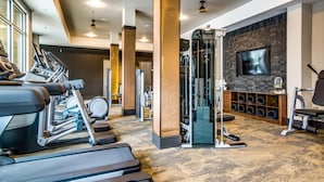 A gym with treadmills, a weight machine, and a TV screen on the wall. - Serene 1BR King Suite Close to Downtown w Fast Wifi (Austin)