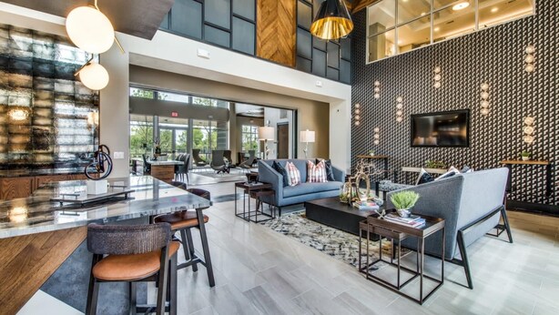 A spacious lobby with a high ceiling, modern furniture, and a large TV on the wall. - Serene 1BR King Suite Close to Downtown w Fast Wifi (Austin)
