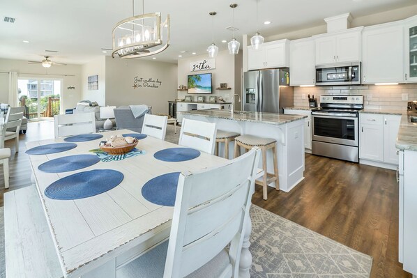 A modern kitchen with white cabinetry, stainless steel appliances, and a central island.