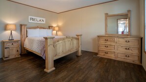 Une chambre à coucher avec un lit en bois, des tables de chevet, une commode et un miroir.