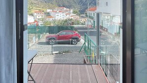 A balcony with a view of a town, mountains, and a red car parked on the street. - Casa Maruca with Roque Nublo view (Tejeda)