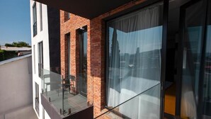 A modern apartment with a balcony, large windows, and a brick facade. - Old City Boutique Hotel (Tbilisi)