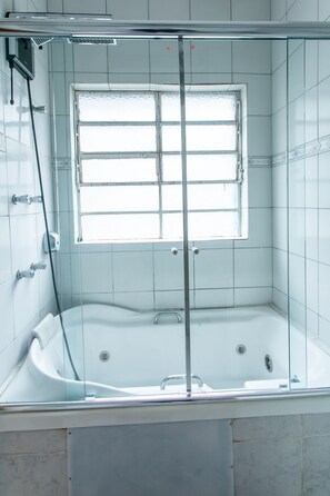 Een bad/douchecombinatie, een bubbelbad, een bidet