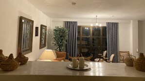Un coin repas avec une table dressée pour deux personnes, une lampe et une plante en pot.