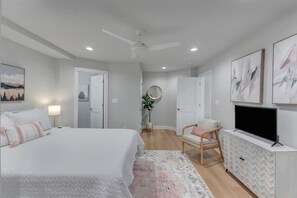 A bedroom with a bed, a chair, a TV, and artwork on the walls. - Clean family-friendly 5BR in the HEART of Virginia's Wine Country (Afton)