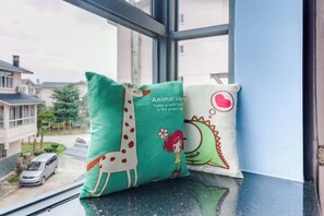 Two pillows on a windowsill with a view of a residential street. - Yilu Gangwan Inn (Wuyishan)