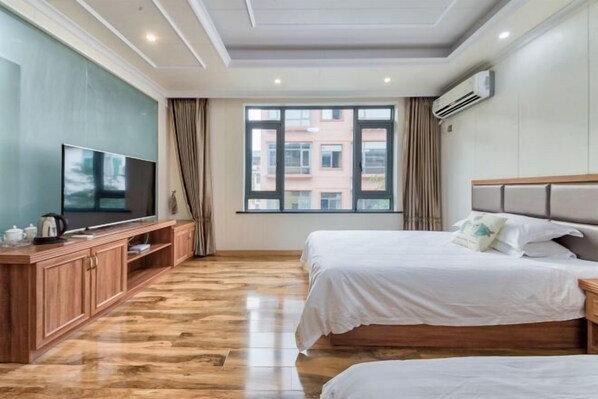 A hotel room with two beds, a TV, a wooden cabinet, and a large window. - Yilu Gangwan Inn (Wuyishan)