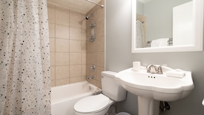 A bathroom with a bathtub, toilet, and sink.