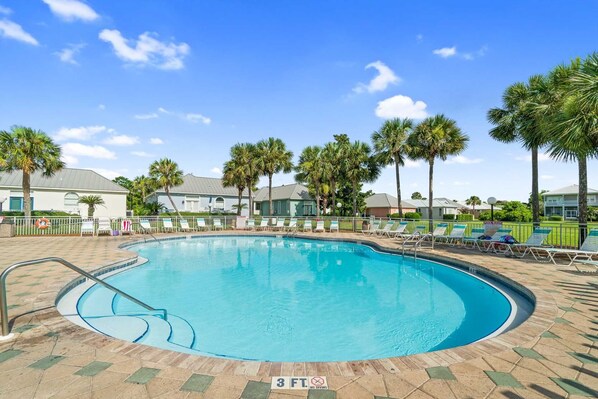 A swimming pool with a 3 ft depth limit, surrounded by lounge chairs and palm trees.