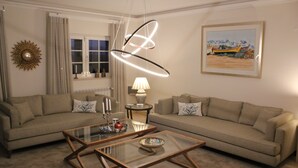 A living room with two sofas, a glass coffee table, a lamp, and a framed painting on the wall. - Villa Tranberg (Silves)