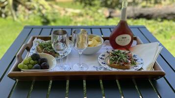 A tray with food and drinks on a table outdoors.