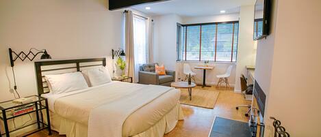 A bedroom with a bed, bedside table, and a desk with a chair.