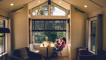 Una habitación de esquina con un ventanal grande, una mesa y una silla.