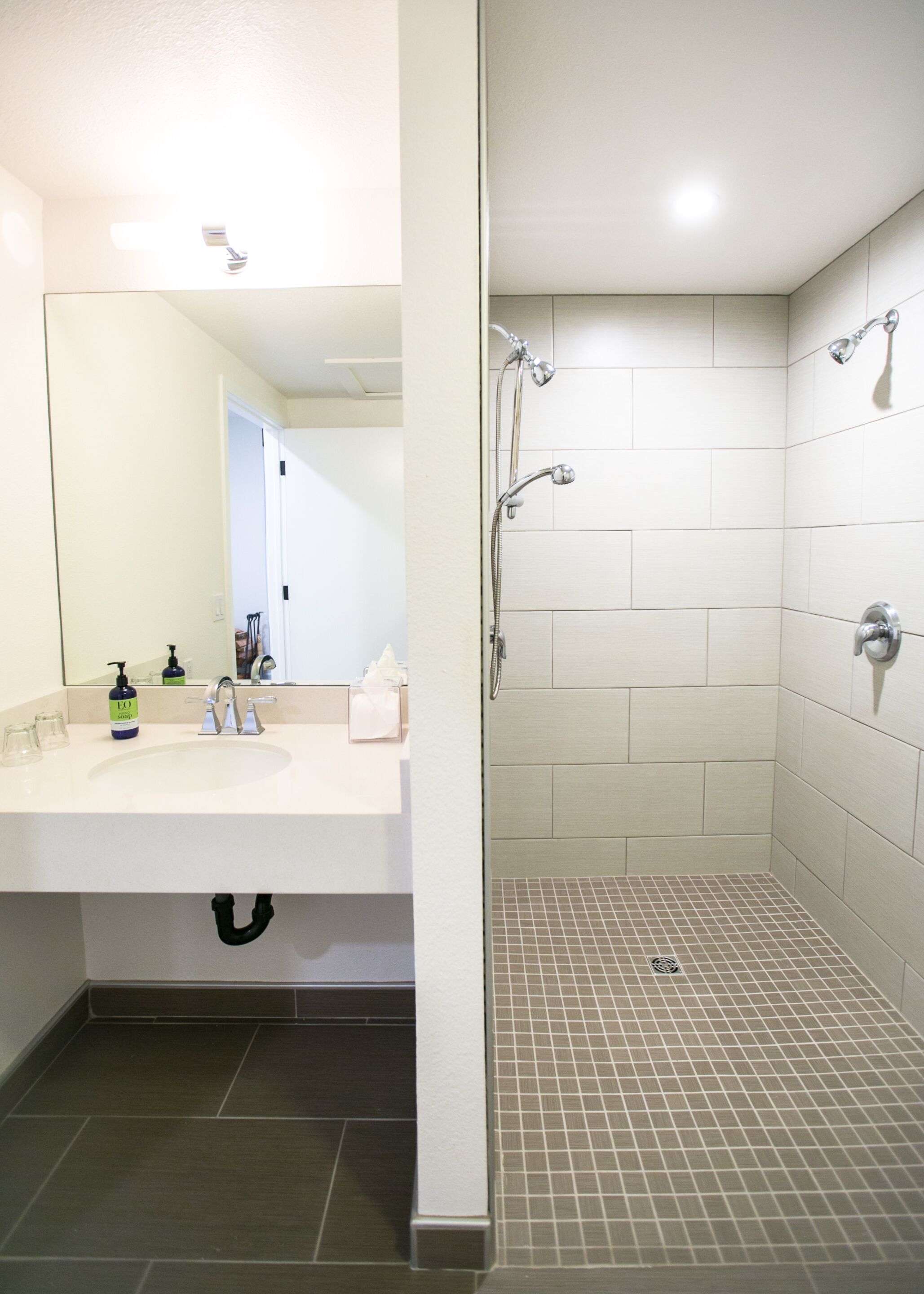 A bathroom with a white sink, mirror, and shower area.