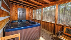 A wooden cabin with a hot tub, a bench, and a door. - Heaven in the Pines: Pure Bliss in the Smokies (Sevierville)