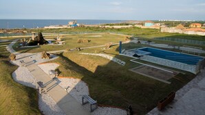 A coastal park with a swimming pool, walking paths, and a view of the sea. - Hogar Dorado Las Gaviotas (Puerto Colombia)