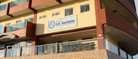 Un edificio de varios pisos con balcones, un letrero que dice "Las Gaviotas" y fachada de ladrillo.