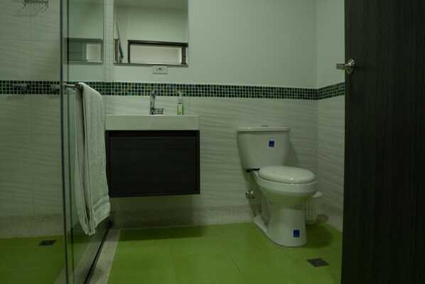 A bathroom with a toilet, sink, and a towel rack.