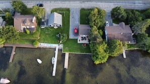 Une vue aérienne d’un quartier résidentiel avec des maisons, un quai et un petit plan d’eau.