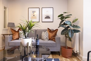 Relax in this stylish living room with a sofa, coffee table, and artwork.