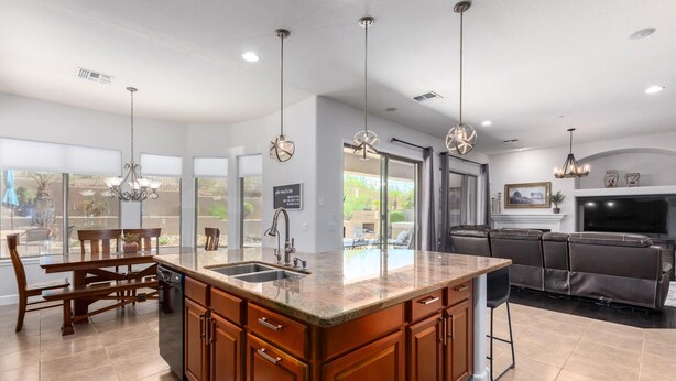 A modern kitchen with a central island, built-in cabinets, and pendant lighting.