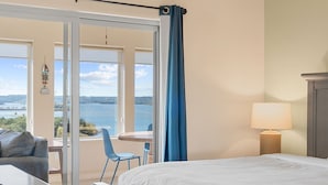 Ein Hotelzimmer mit Bett, Schreibtisch, Stuhl und Meerblick.