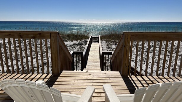 A wooden deck with two white chairs facing a beach. - Amazing Views! Elegant Gulf Front Home: Elevator, Huge Deck/Walkover, Beach Gear (Pensacola Beach)