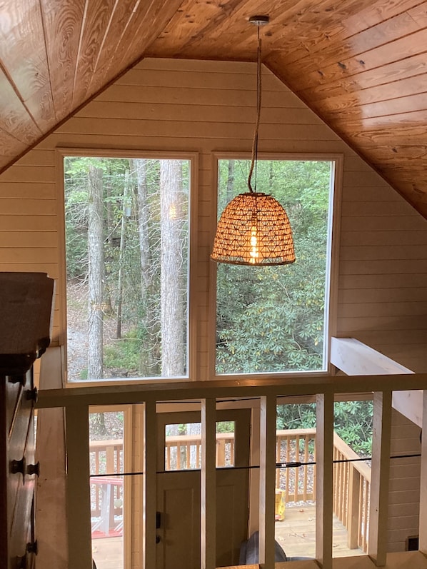 Enjoy a forest view from the large window in this room, featuring a door to an outdoor deck.
