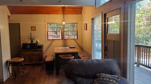 Enjoy meals in the dining area with a wooden table and chairs, or relax on the leather couch.