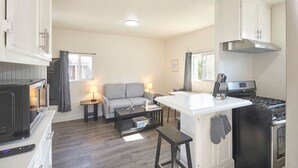 Une cuisine compacte avec un îlot central, un canapé et une table à manger.