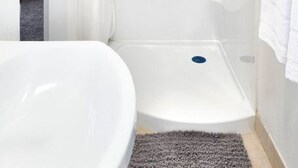 Un baño moderno con cabina de ducha, inodoro y bañera.