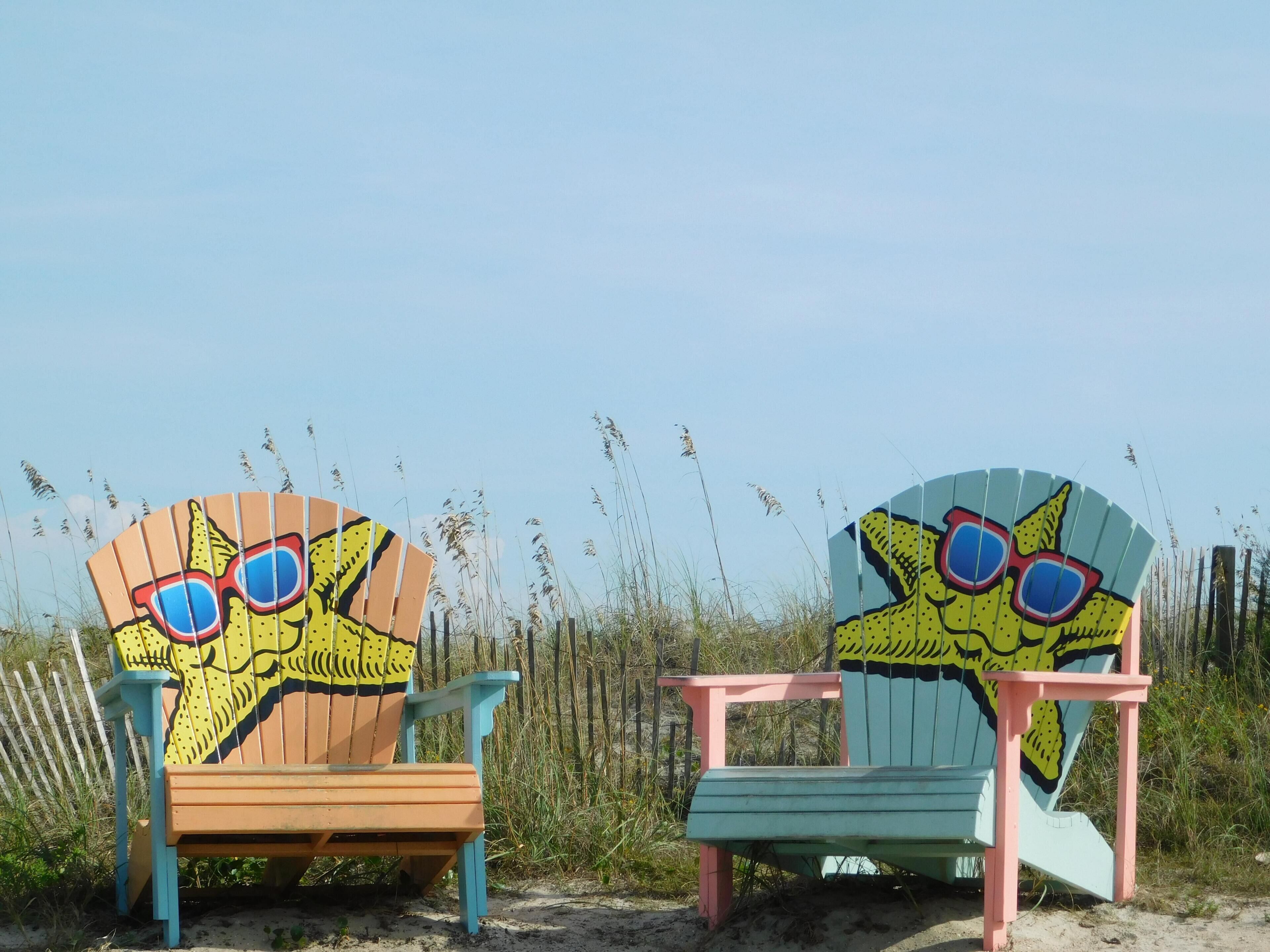Two beach chairs with cartoon faces and sunglasses.